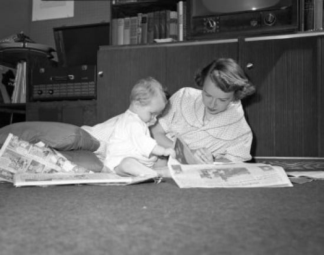 Posterazzi Mother and baby reading newspapers on floor Canvas Art - (24 x 36)
