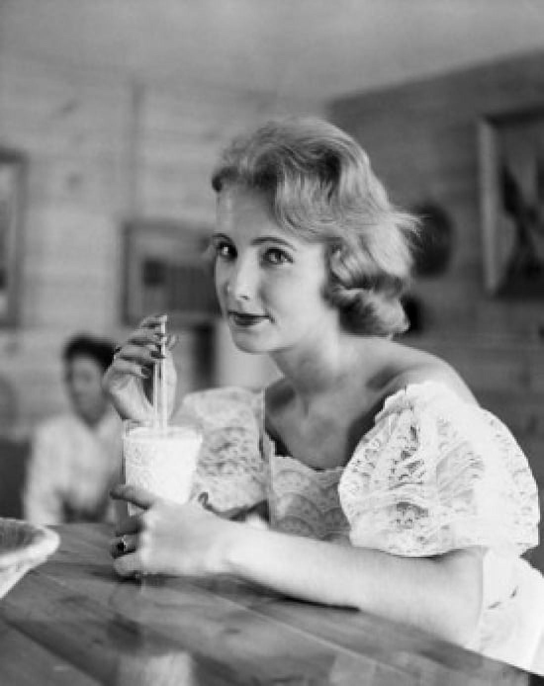 Posterazzi Portrait of a young woman drinking a milkshake at a bar counter Canvas Art - (24 x 36)