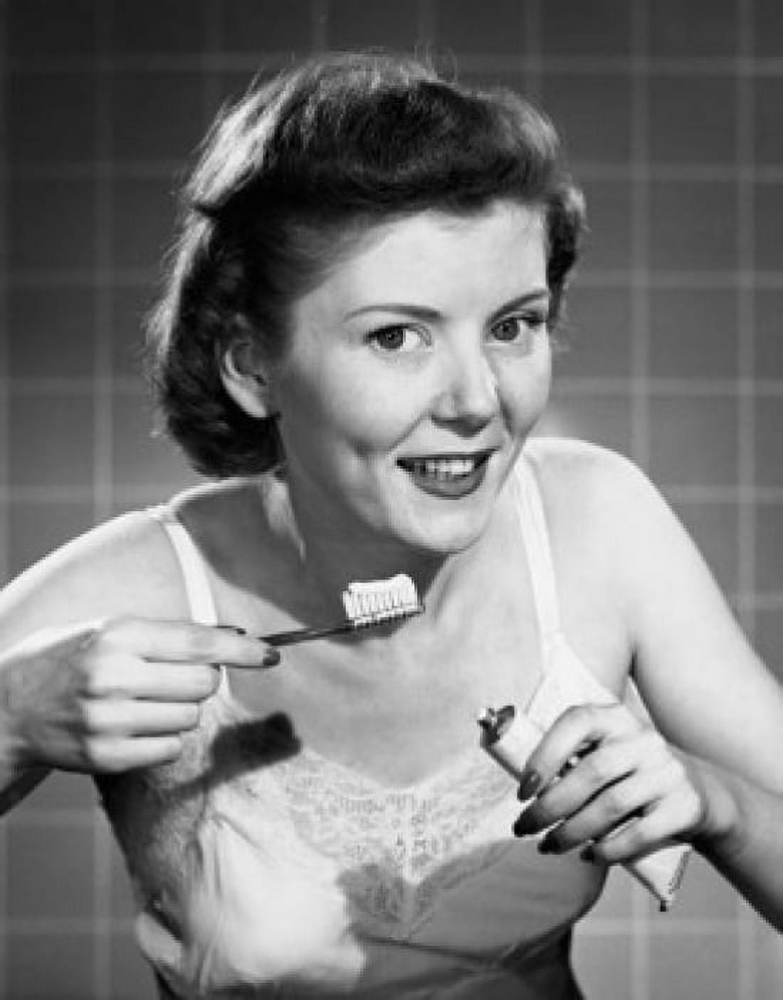 Posterazzi Portrait of a young woman holding a toothbrush and toothpaste Canvas Art - (24 x 36)