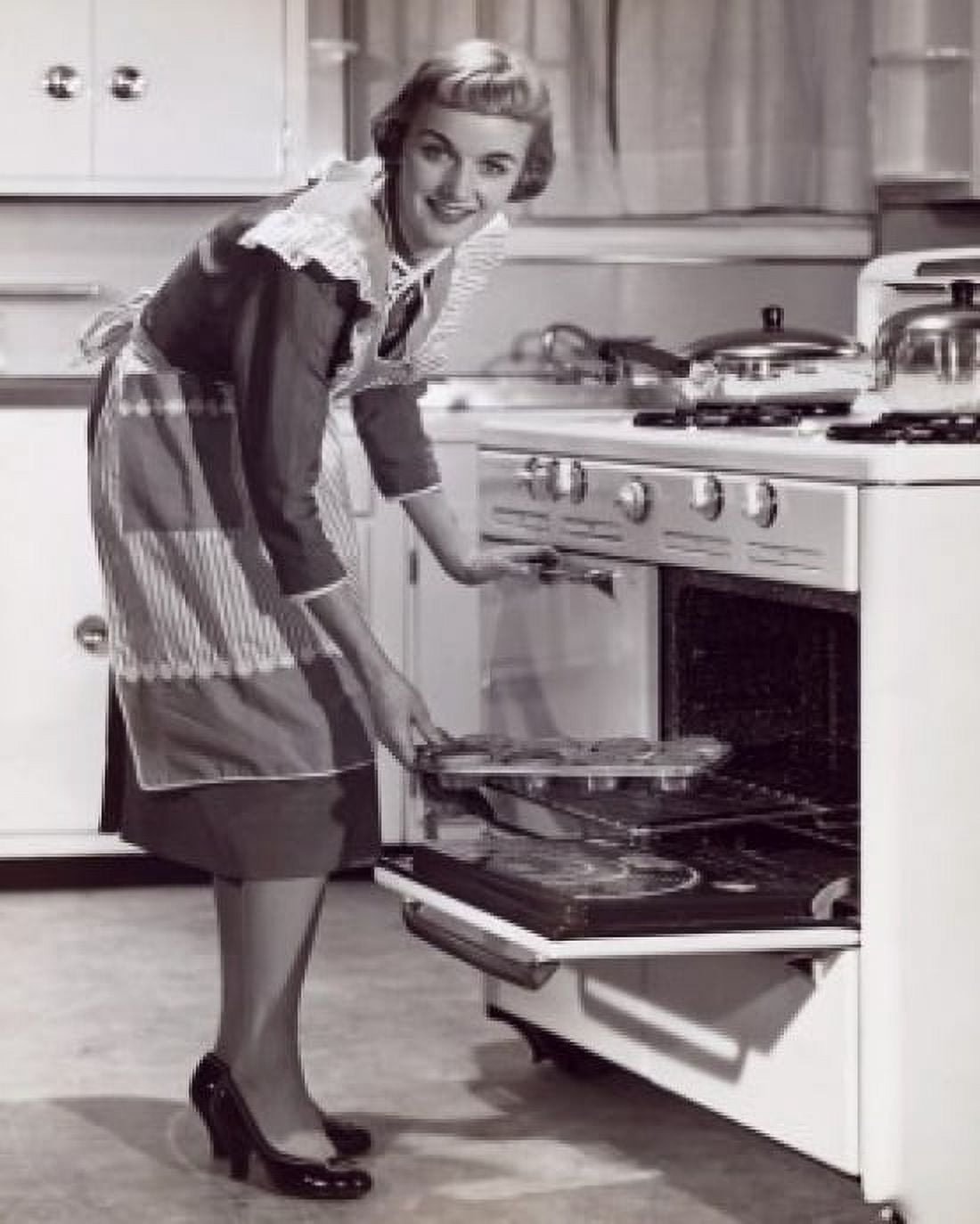 Posterazzi Portrait of a young woman putting food into an oven Canvas Art - (24 x 36)