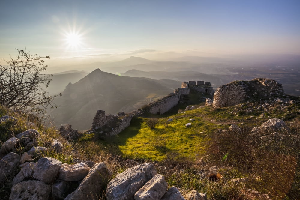 Posterazzi Ruins of a stone wall and buildings with a sunburst and mountains Corinth Greece Canvas Art - Reynold Mainse Design Pics (38 x 24)