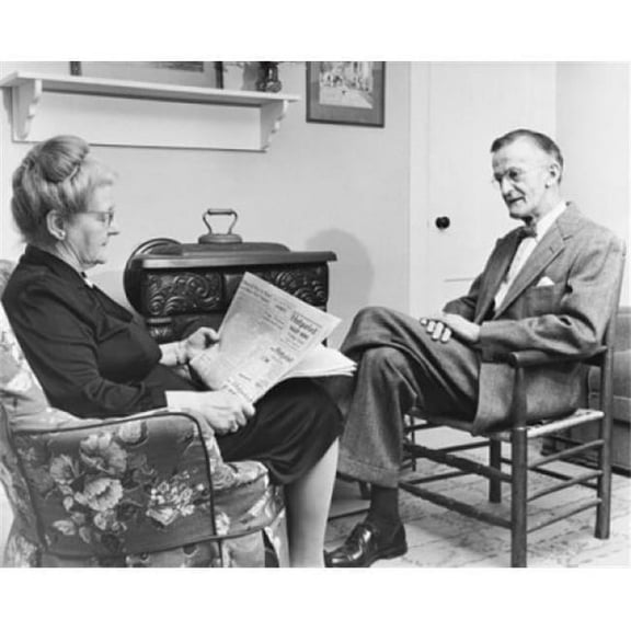 Posterazzi SAL2558598 Senior Woman Reading a Newspaper with a Senior Man Sitting in Front of Her Poster Print - 18 x 24 in.