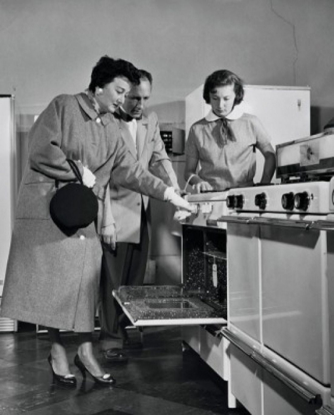 Posterazzi Salesman showing an oven to female customers in a store Canvas Art - (24 x 36)