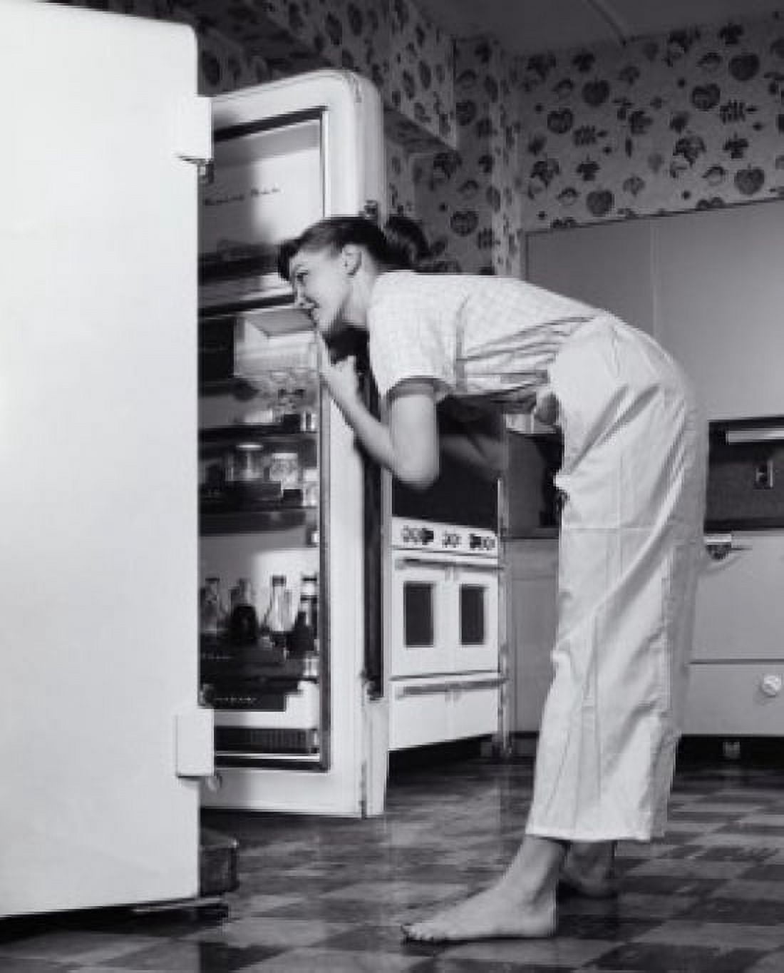 Posterazzi Side profile of a young woman looking in a refrigerator Canvas Art - (24 x 36)