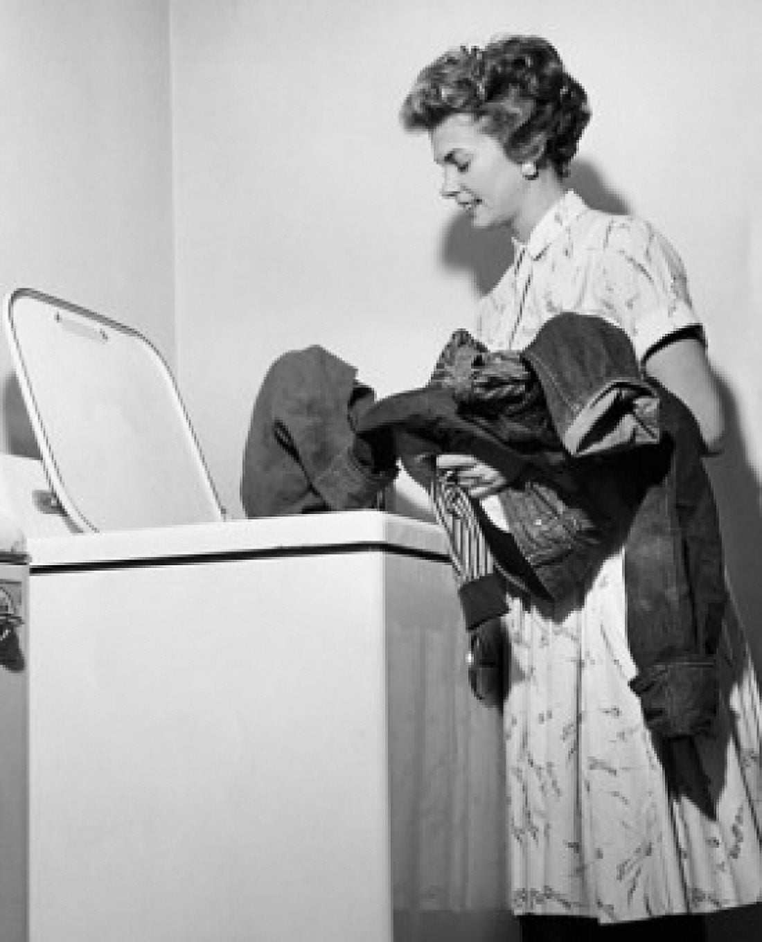 Posterazzi Side profile of a young woman putting clothes into a washing machine Canvas Art - (24 x 36)