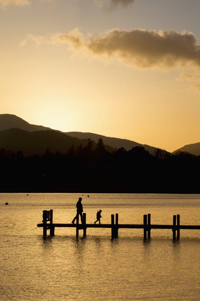Posterazzi Silhouette of a parent and child walking on a dock on a tranquil lake at sunset South Lakeland District England Canvas Art - John Short Design Pics (24 x 38)