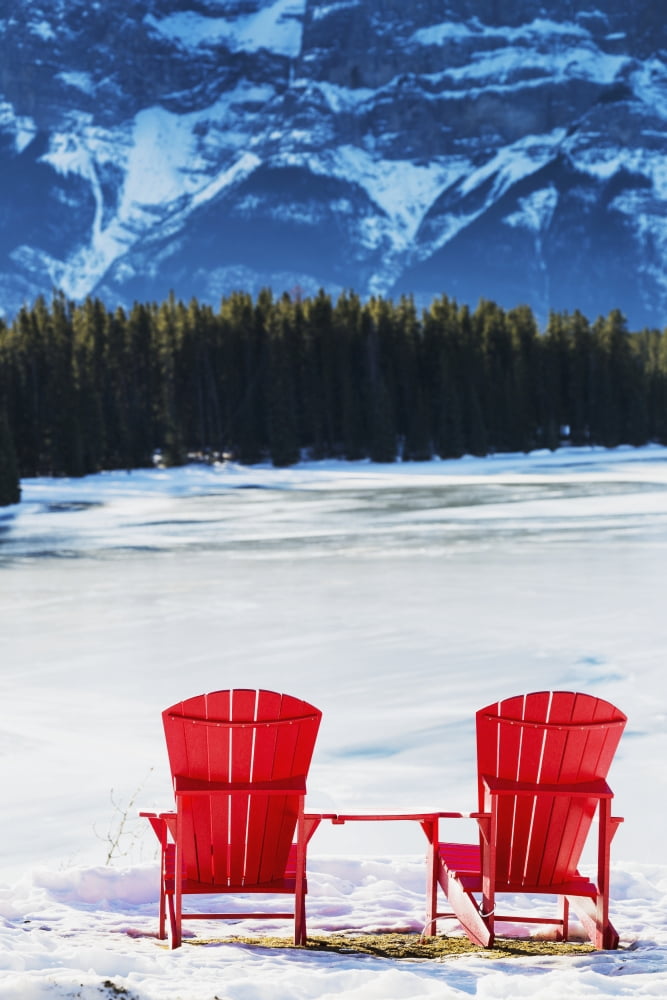 Posterazzi Two red chairs on snow covered ridge overlooking frozen lake with snow covered mountain cliff in the background Banff Alberta Canada Canvas Art - Michael Interisano  Design Pics (24 x 38)