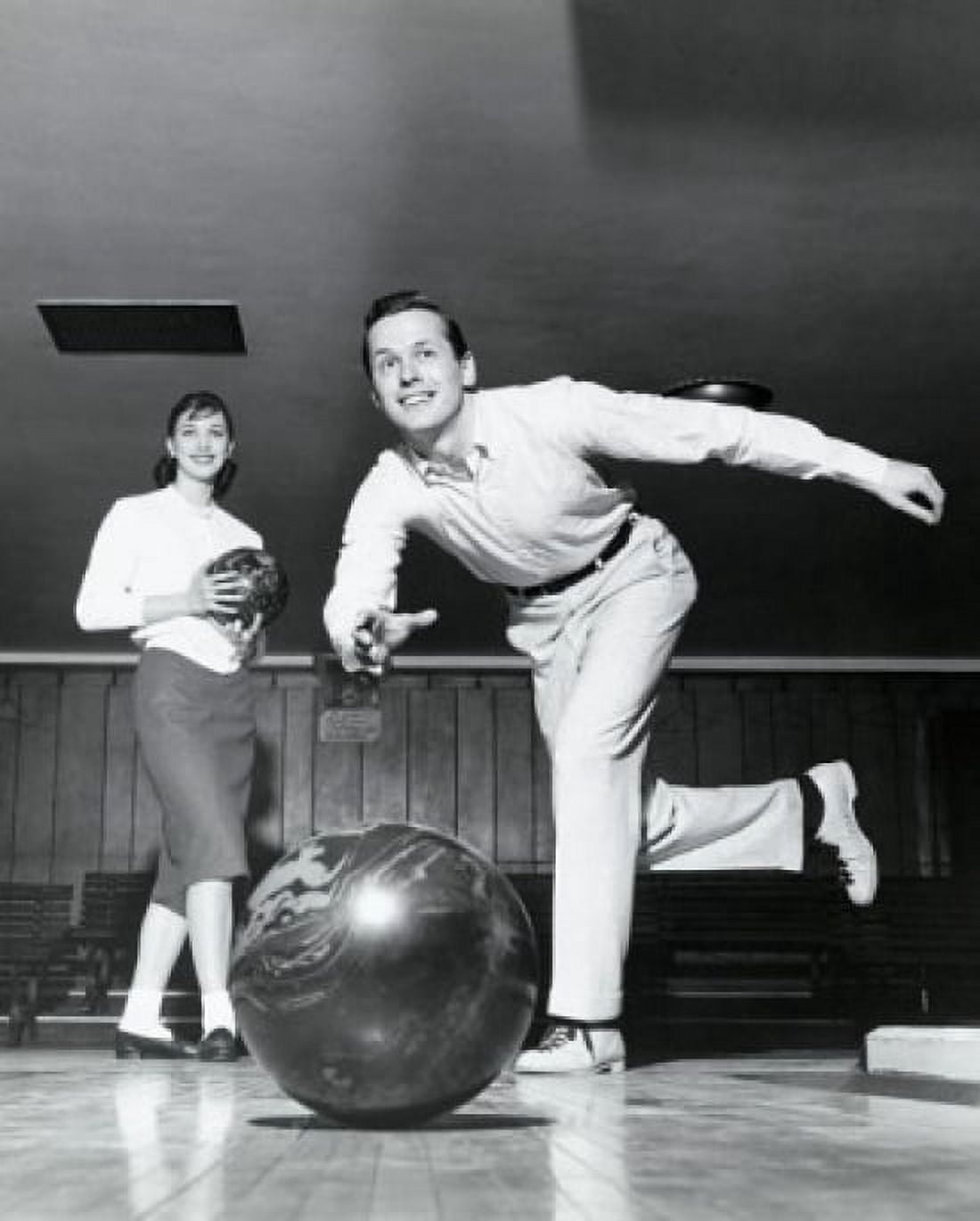 Posterazzi Young man bowling in a bowling alley with a young woman behind him Canvas Art - (24 x 36)