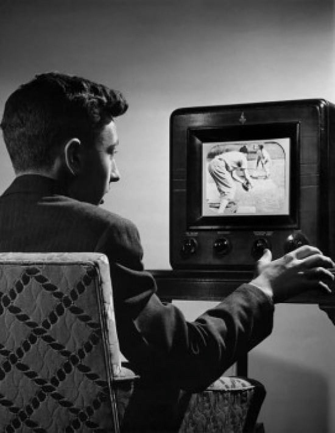 Posterazzi Young man changing channels of a television Canvas Art - (24 x 36)
