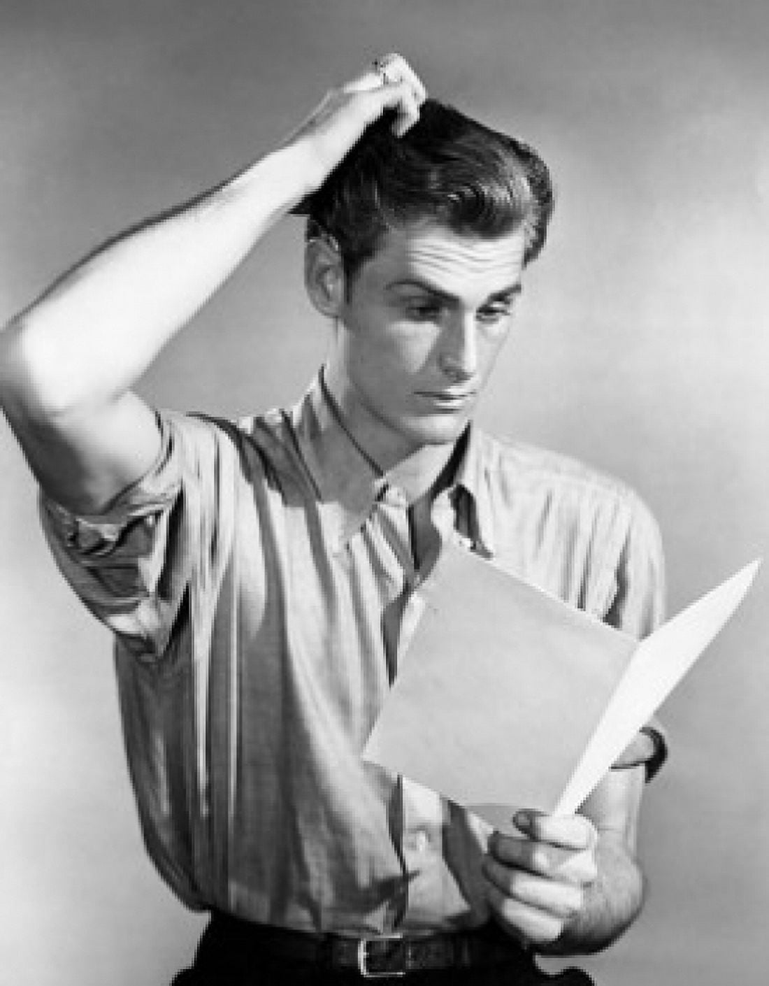 Posterazzi Young man reading a paper and scratching his head Canvas Art - (24 x 36)