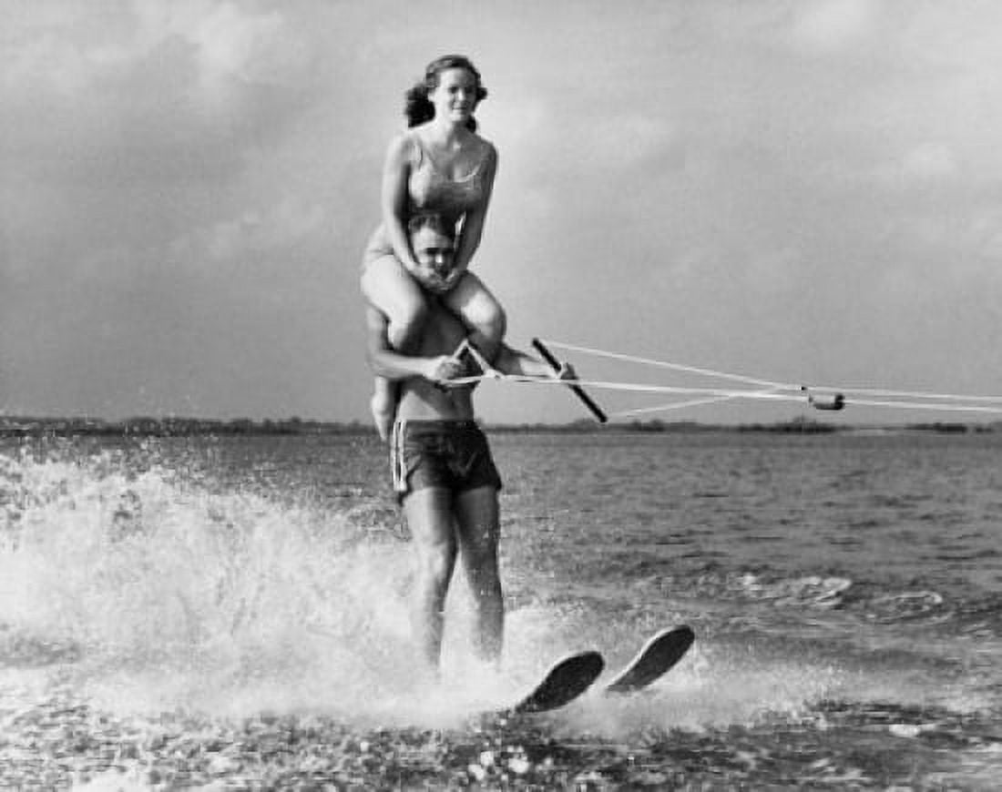 Posterazzi Young man waterskiing with young woman sitting on his shoulder Canvas Art - (24 x 36)