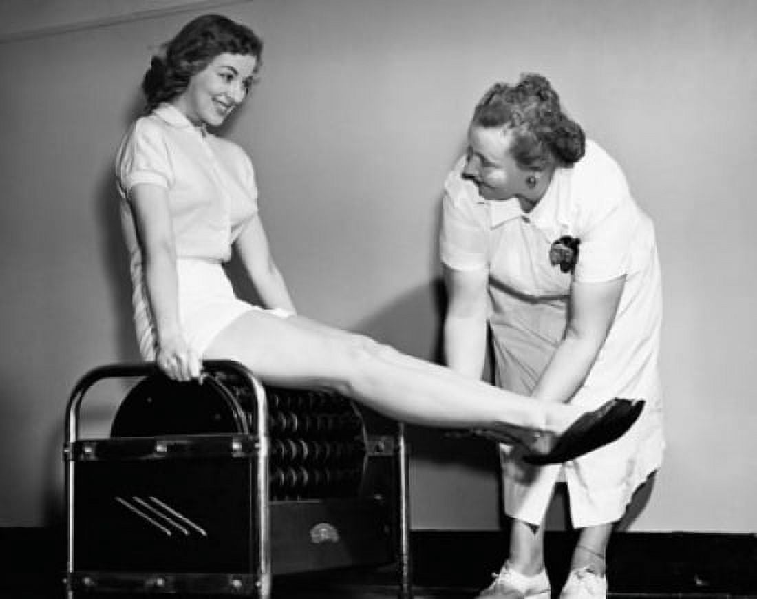 Posterazzi Young woman exercising on an exercising machine with the help of a female instructor Canvas Art - (24 x 36)
