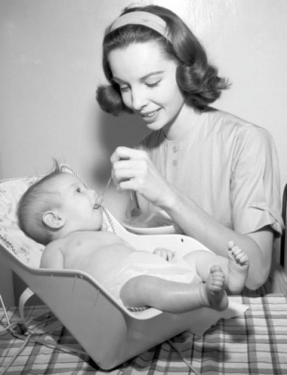 Posterazzi Young woman feeding baby sitting in bouncer Canvas Art - (24 x 36)