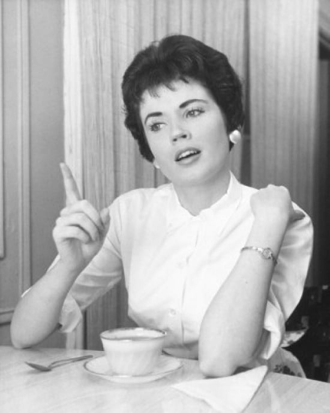 Posterazzi Young woman pointing and sitting with a tea cup Canvas Art - (24 x 36)