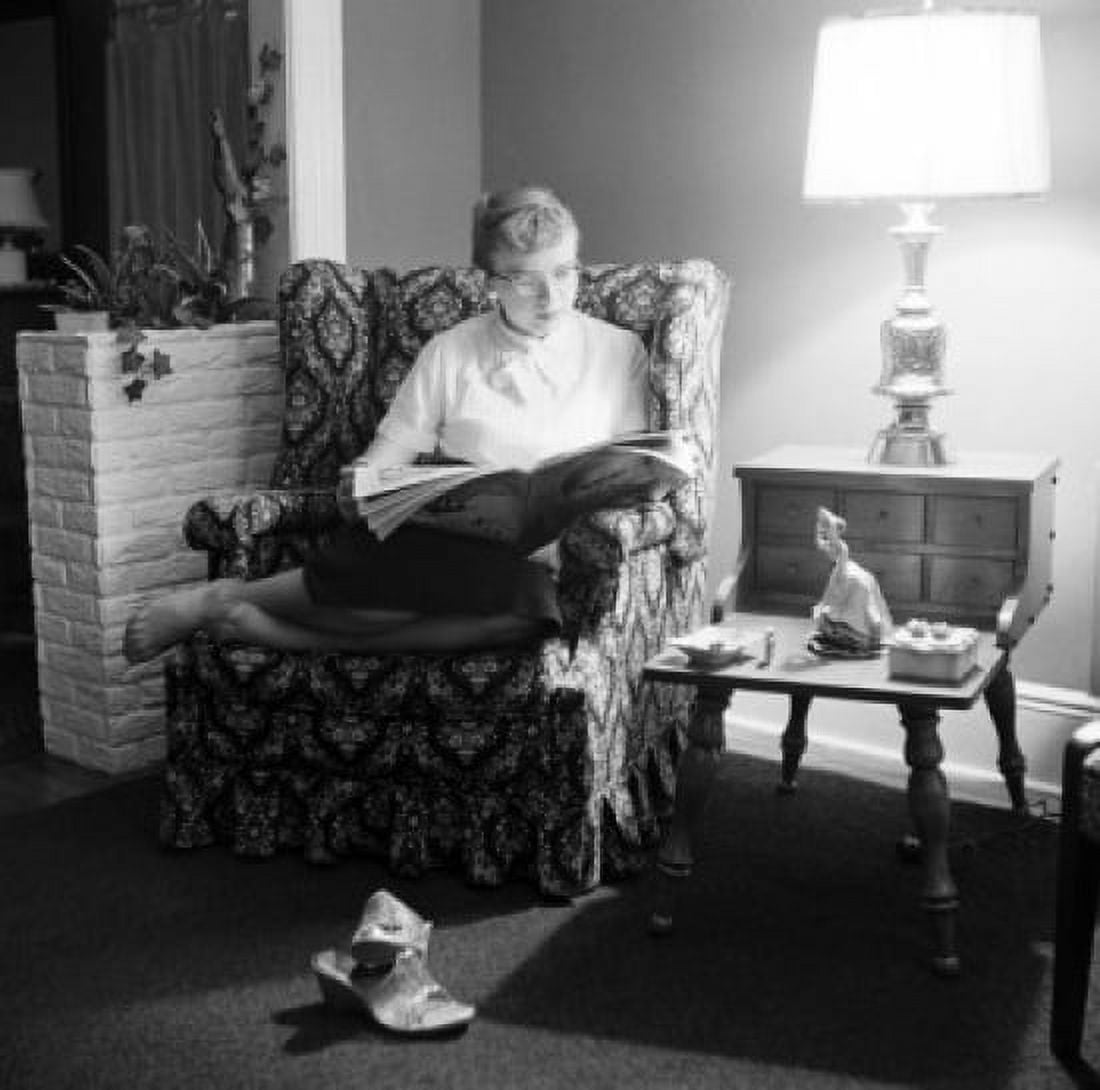 Posterazzi Young woman reading magazine in living room Canvas Art - (24 x 36)