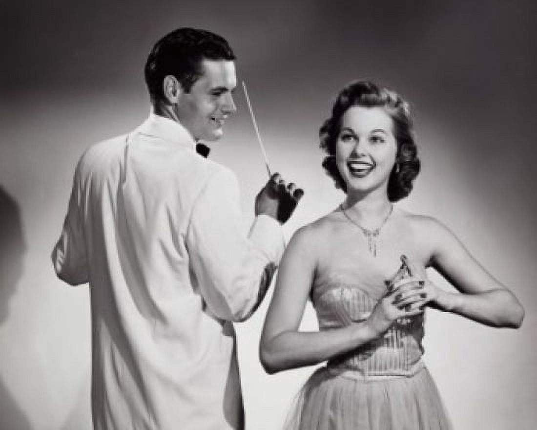 Posterazzi Young woman singing with a music conductor holding a conductors baton behind her Canvas Art -  (24 x 36)