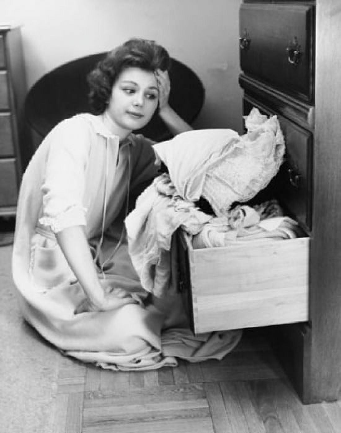 Posterazzi Young woman sitting on the floor looking at clothes in a drawer Canvas Art - (24 x 36)