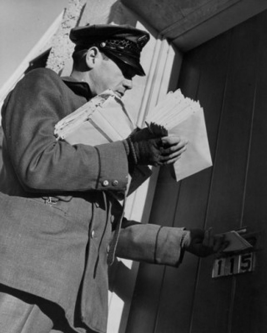 Postman dropping mail in mail slot low angle view Canvas Art - (18 x 24)