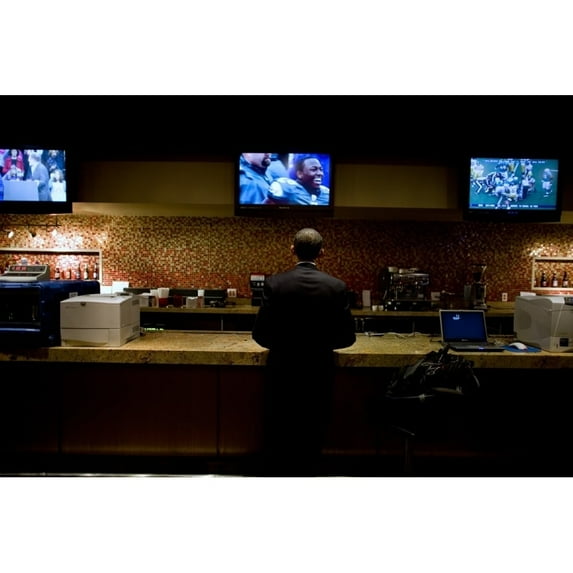 President Barack Obama Watches A Televised Football Game In A Holding Room Before A Campaign Rally At The Prudential