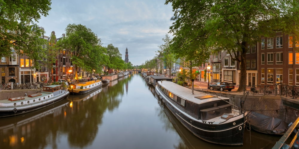 Prinsengracht canal at dusk with Westerkerk in distance Amsterdam North Holland Netherlands Canvas Art - Panoramic Images (9 x 27)