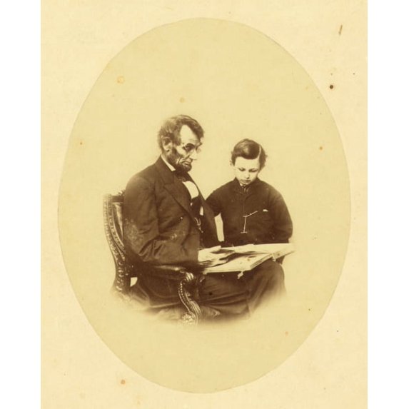 Print: Abraham Lincoln, U.S. President, Looking At A Photo Album With His
