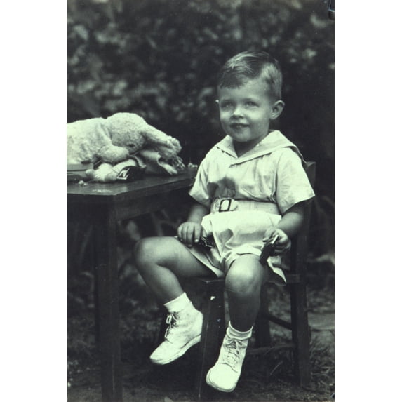 Print: Portrait Of A Young Boy Seated At An Outdoor Table, Facing Front