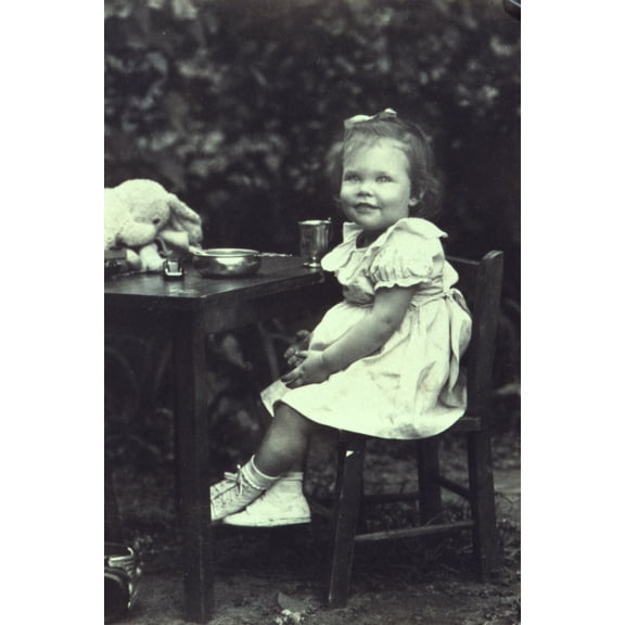 Print: Portrait Of A Young Girl Seated At An Outdoor Table, Facing Front