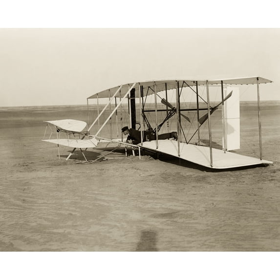 Print: Wilbur In Prone Position In Damaged Machine, On Ground After