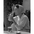 thumbnail image 1 of Print: Woman Wearing Headscarf Seated At Table With Drink, circa 1940, 1 of 4