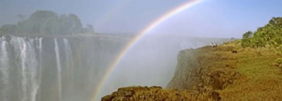 Rainbow form in the spray created by the water cascading over the Victoria Falls Zimbabwe Canvas Art - Panoramic Images (18 x 7)