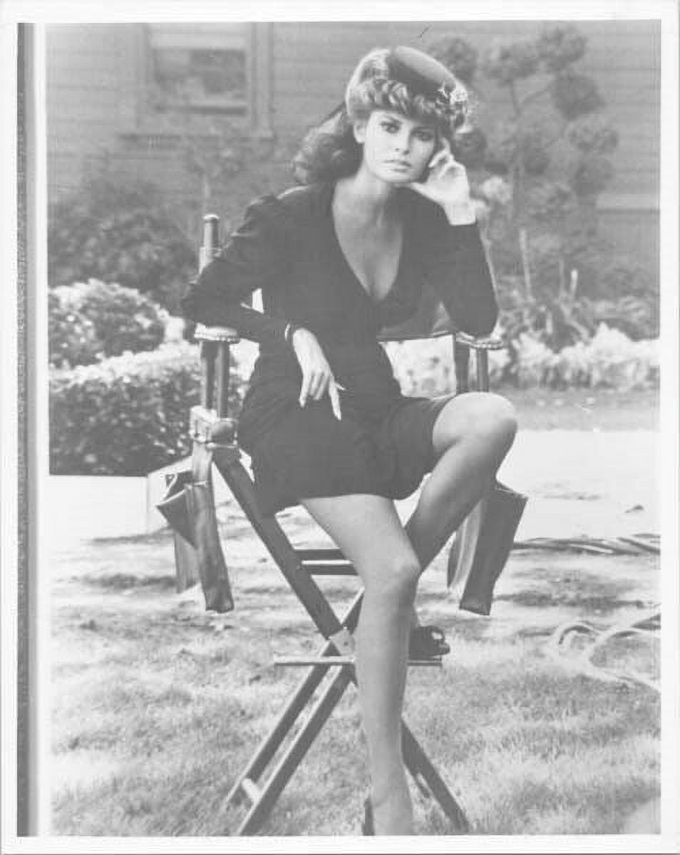 Raquel Welch in short black dress sitting on studio chair between takes ...