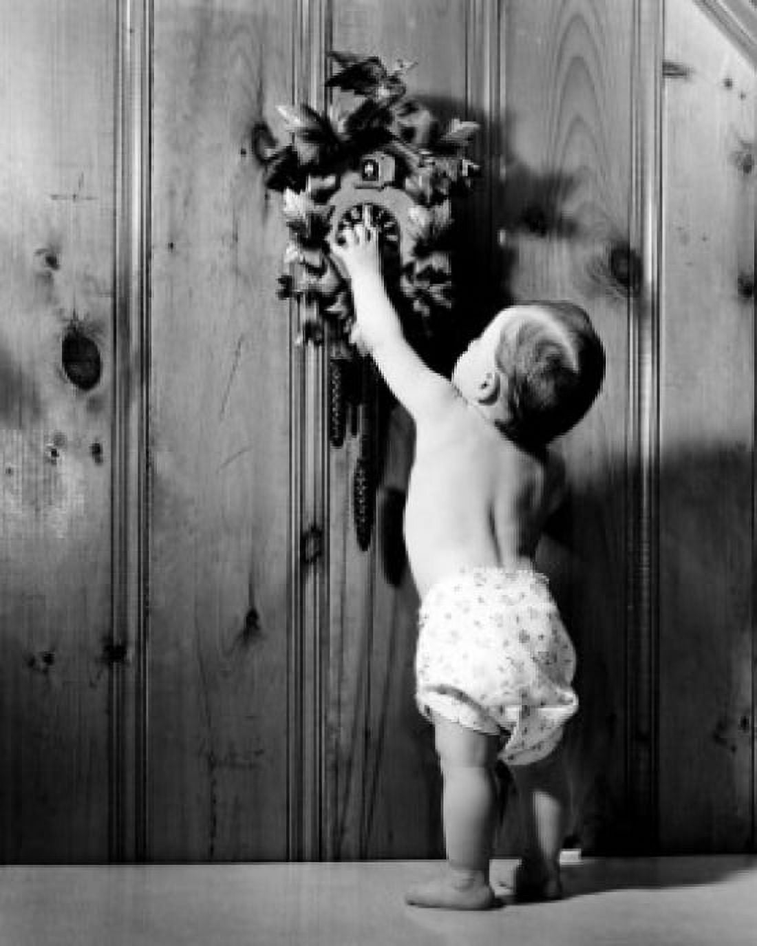 Rear view of a baby boy reaching for a cuckoo clock Canvas Art - (18 x 24)