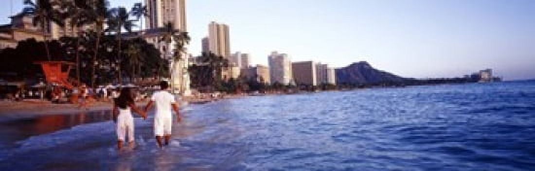 Rear view of a couple wading on the beach Waikiki Beach Honolulu Oahu Hawaii USA Canvas Art - Panoramic Images (18 x 6)