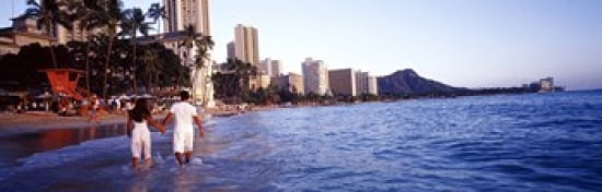 Rear view of a couple wading on the beach Waikiki Beach Honolulu Oahu Hawaii USA Canvas Art - Panoramic Images (36 x 12)
