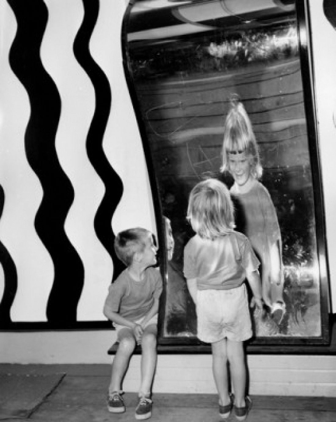 Rear view of a girl and a boy looking in a fun house mirror Canvas Art - (24 x 36)