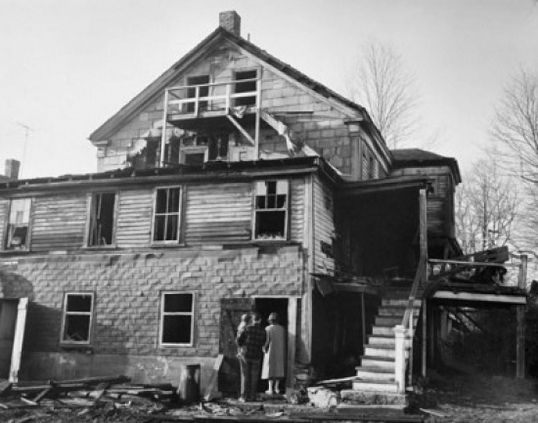 Rear view of a man and a woman with their child standing at a door of a burnt house Canvas Art - (24 x 36)
