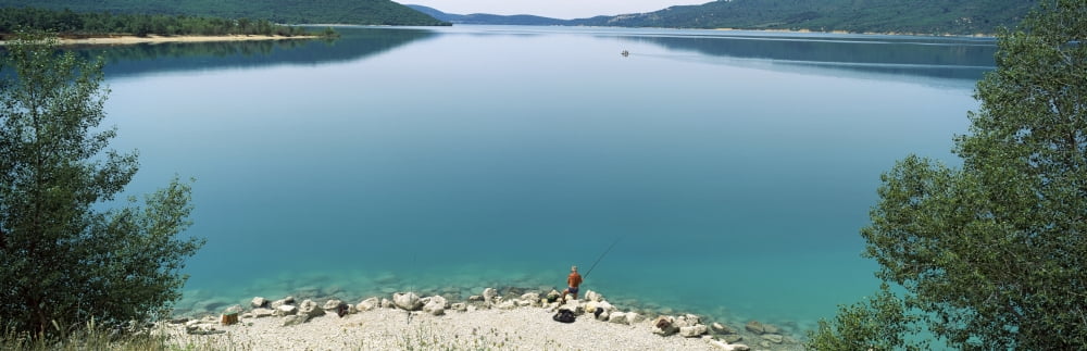 Rear view of a person fishing in a lake Lake of Sainte-Croix Provence-Alpes-Cote dAzur France Canvas Art - Panoramic Images (27 x 9)