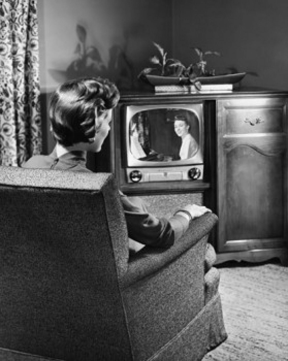 Rear view of a woman sitting in an armchair and watching television Canvas Art - (18 x 24)