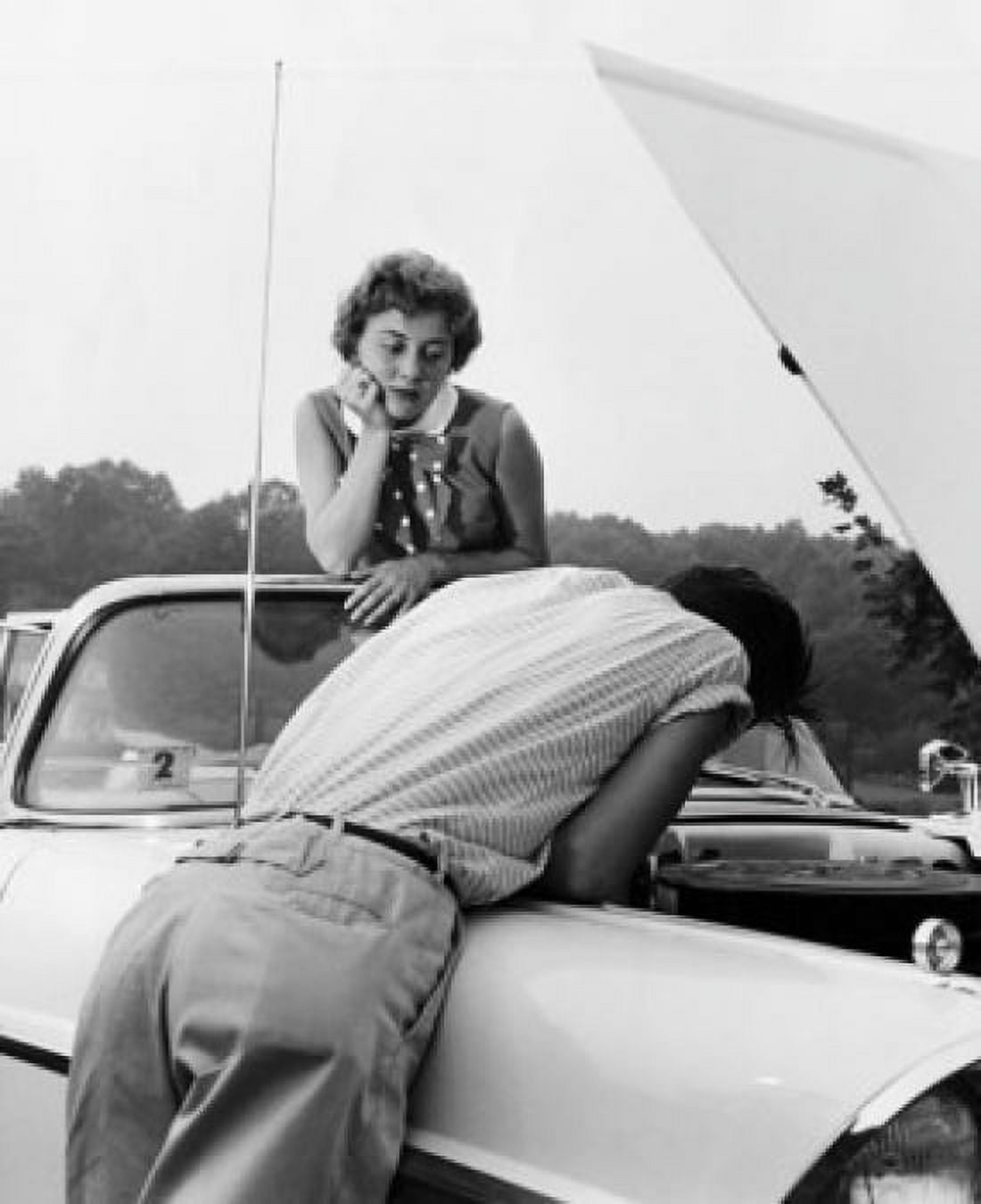 Rear view of a young man examining his car with a young woman looking at him Canvas Art -  (18 x 24)