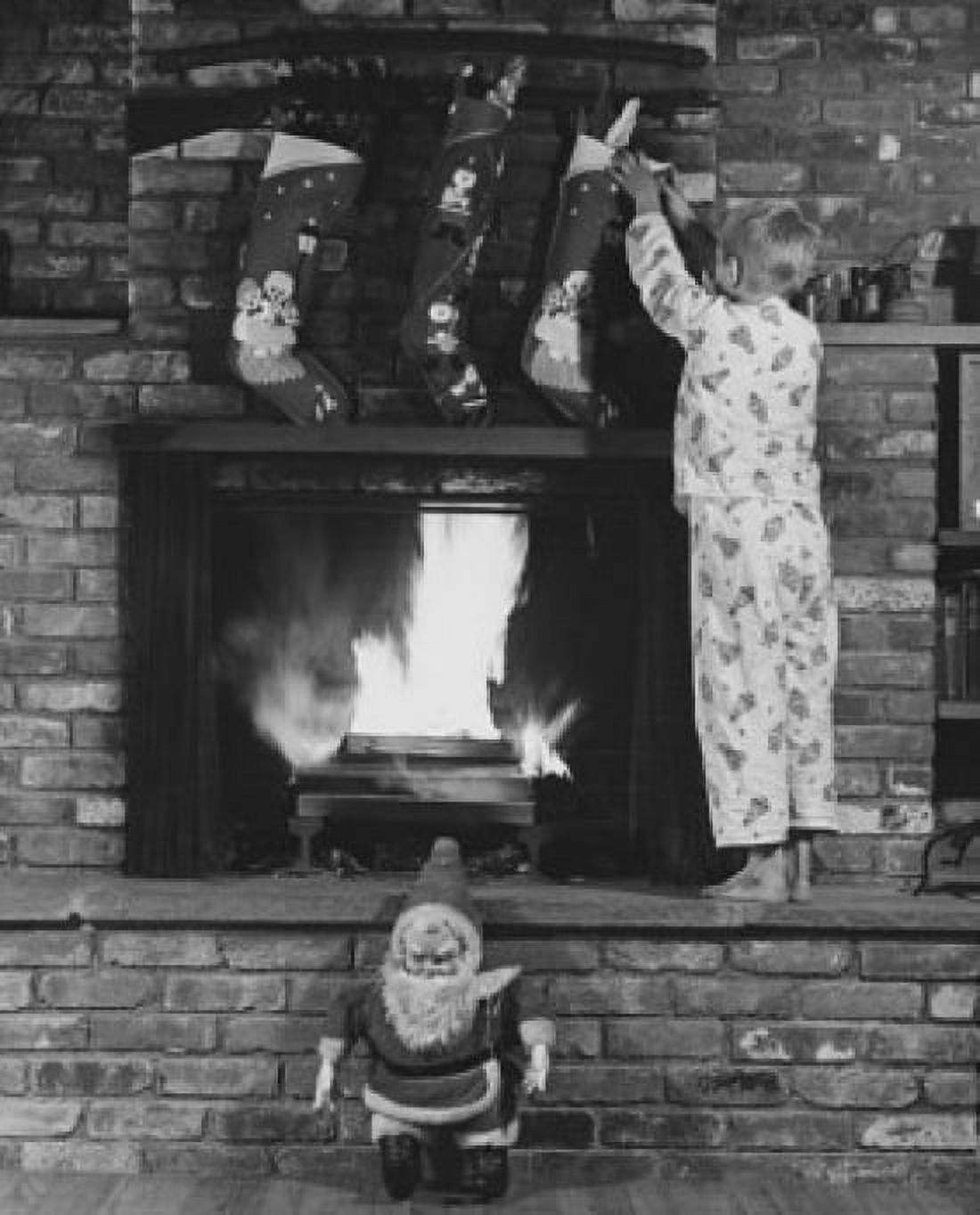 Rear view of boy standing on fireplace and grabbing Christmas stocking Canvas Art - (24 x 36)