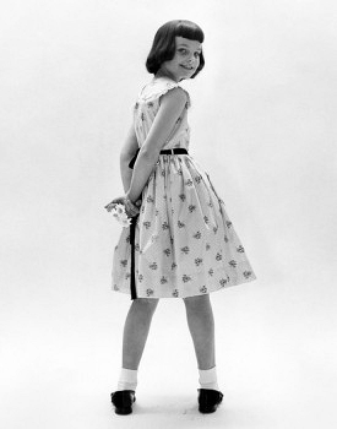 Rear view of girl looking around to smile at camera Canvas Art - (24 x 36)