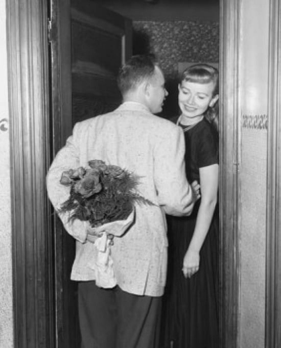 Rear view of mid adult man standing with mid adult woman at doorway hiding bouquet of flowers behind back Canvas Art - (18 x 24)