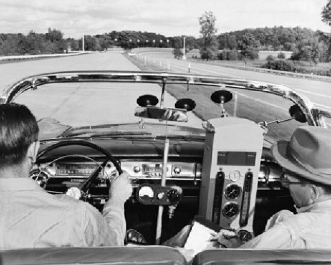 Rear view of two men driving a vintage car with equipment to measure the fuel consumption Canvas Art - (18 x 24)