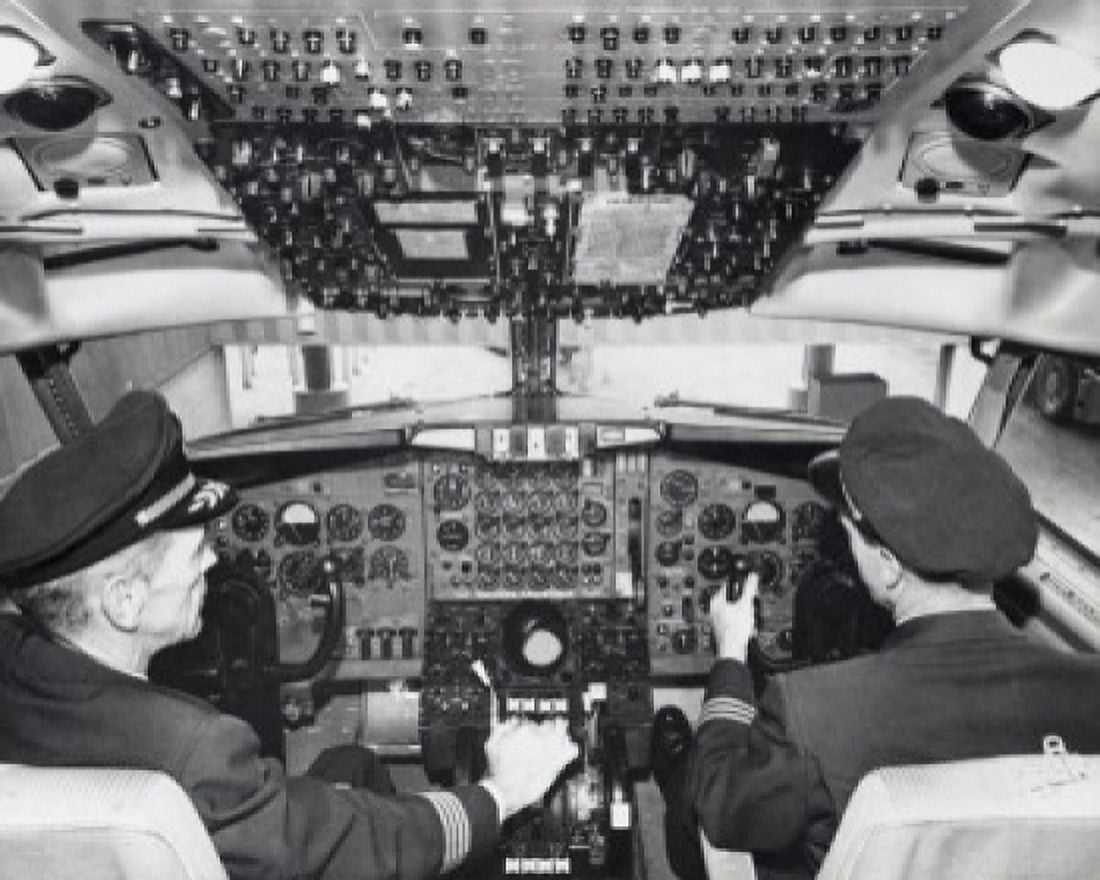 Rear view of two pilots sitting in the cockpit of an airplane Canvas Art - (24 x 36)