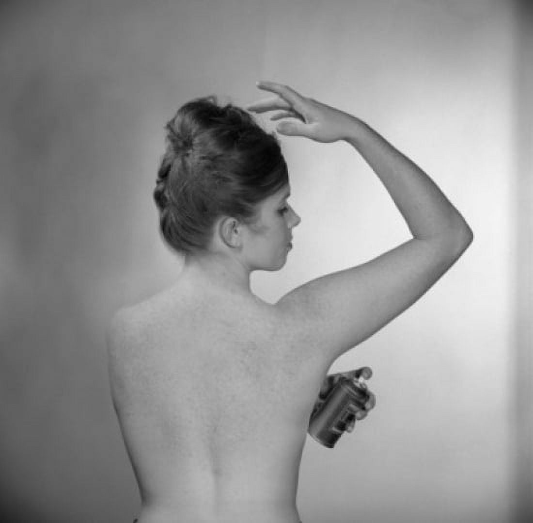 Rear view of young woman using deodorant Canvas Art - (24 x 36)