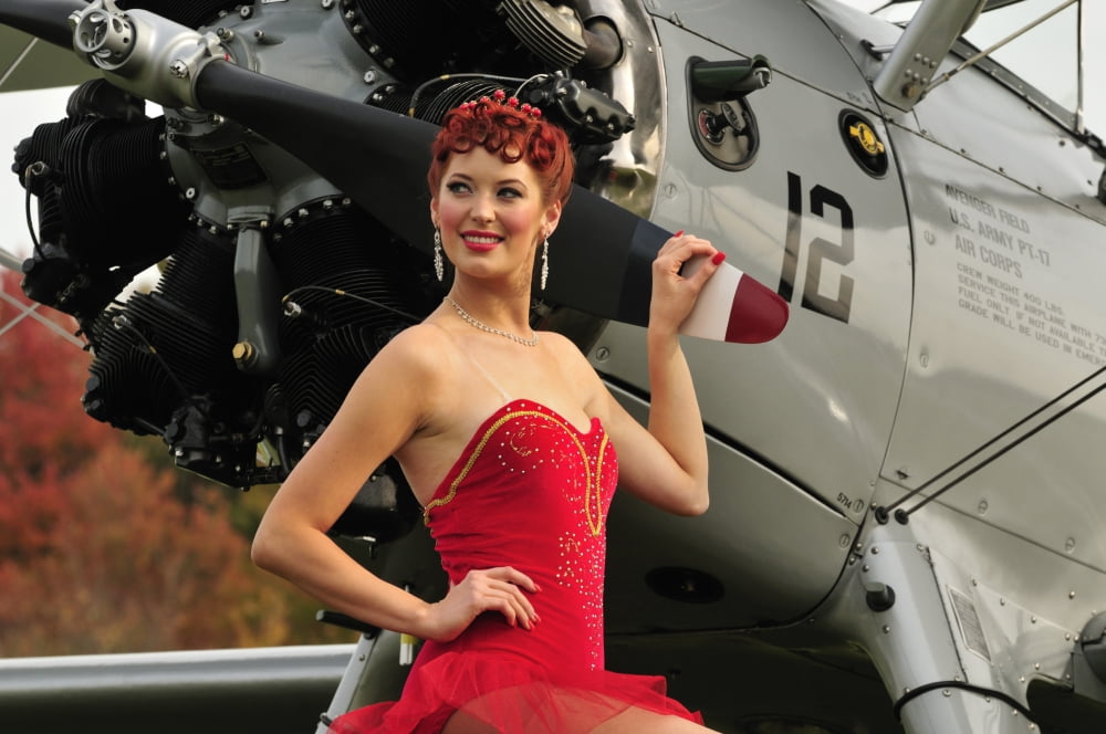 Redhead pin-up girl in 1940s style dancer attire holding on to a vintage aircraft propeller Canvas Art - Christian KiefferStocktrek Images (35 x 23)