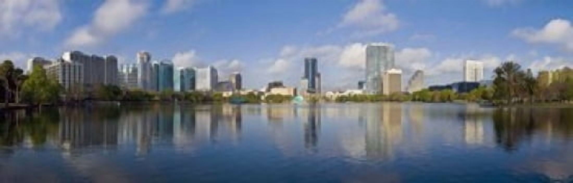 Reflection of buildings in a lake Lake Eola Orlando Orange County Florida USA 2010 Canvas Art - Panoramic Images (36 x 12)