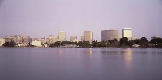 Reflection of skyscrapers in a lake Lake Merritt Oakland California USA Canvas Art - Panoramic Images (24 x 12)