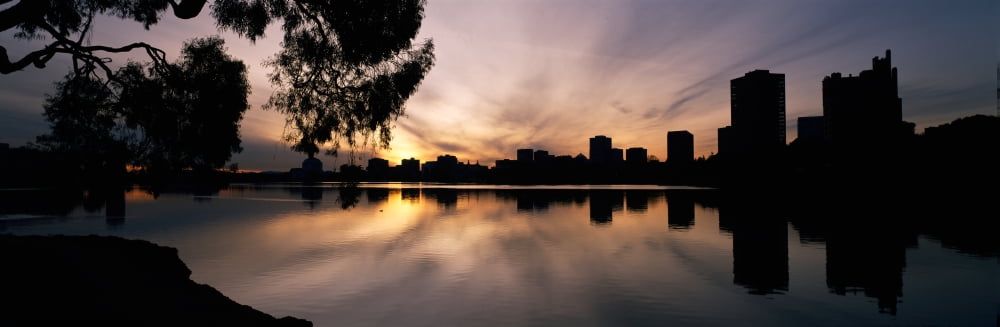 Reflection of skyscrapers in a lake Lake Merritt Oakland California USA Canvas Art - Panoramic Images (27 x 9)