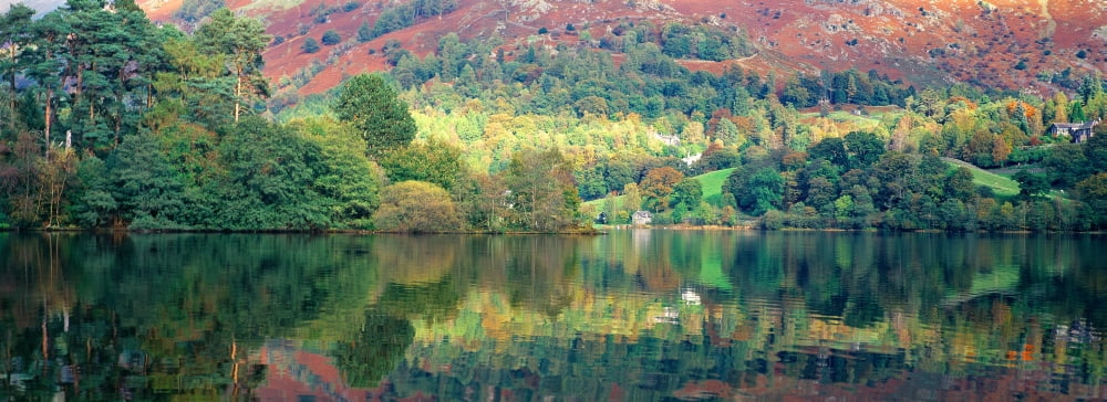 Reflection of trees in a lake Grasmere Lake District Lake District National Park England Canvas Art - Panoramic Images (27 x 9)